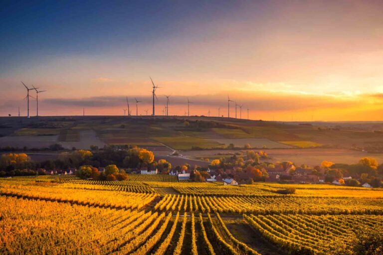 A futuristic city with golden fields and wind mills, showing what a tech-focused Utopia could be like.