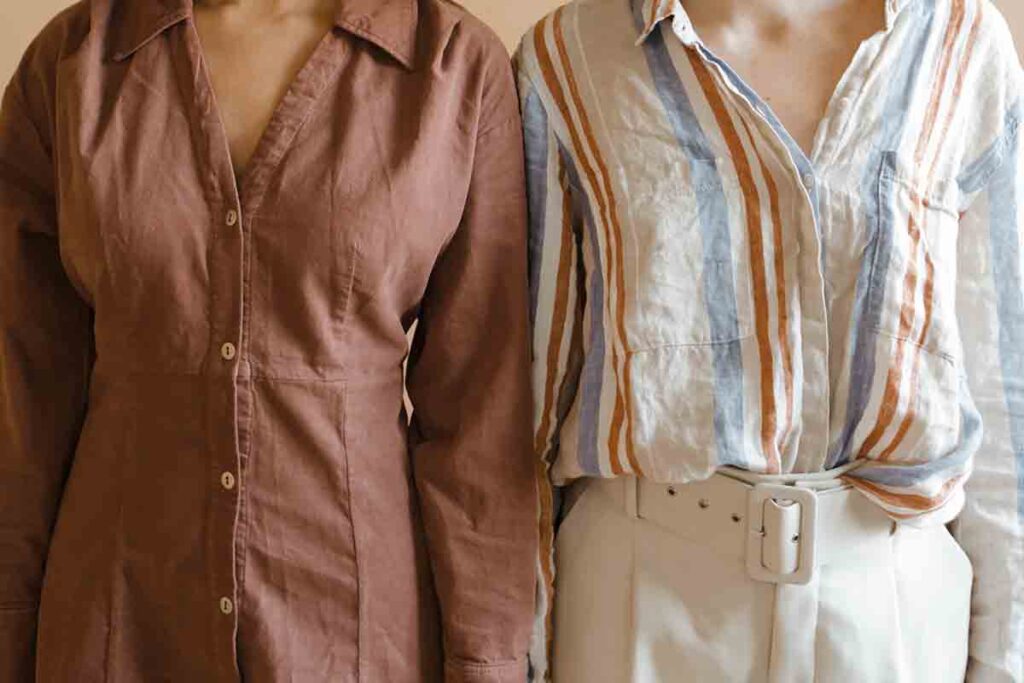 Two women wearing organic natural fiber clothing, showing differences between natural vs synthetic fibers. The woman on the left wears a brown cotton button-down. The woman on the right wears a striped white, red and blue cotton button down.