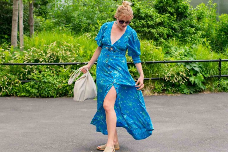 Woman wearing blue dress rented from Nuuly clothing services