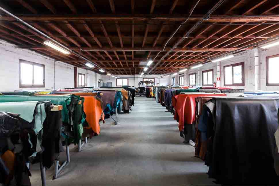 A workroom with animal hides draped over tables before the tanning process to make sustainable leather from brand ECCO Leather.