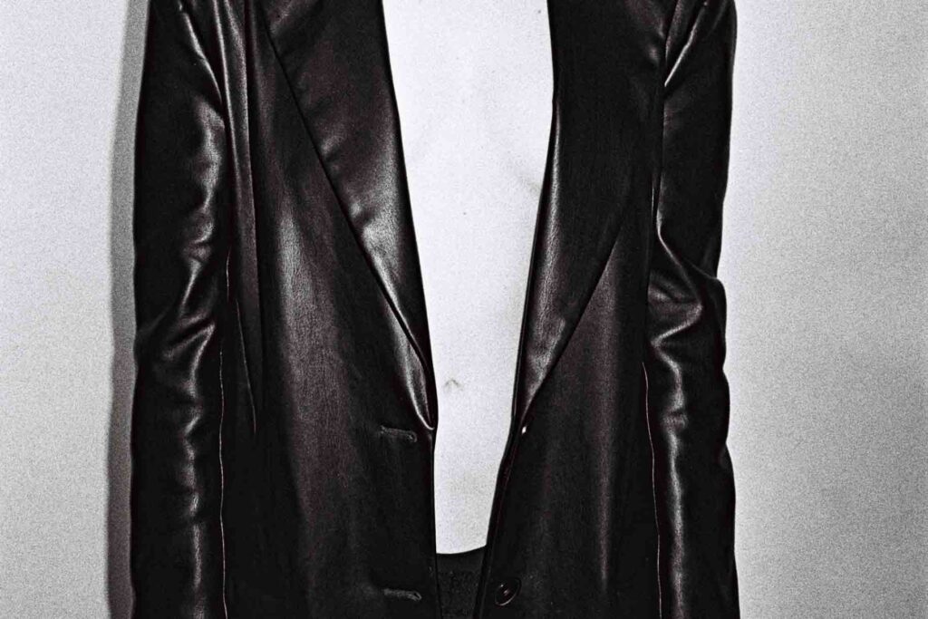 A woman wears a black real leather jacket and white t shirt