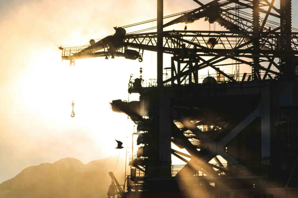 Machinery on an oil rig with sun in the background