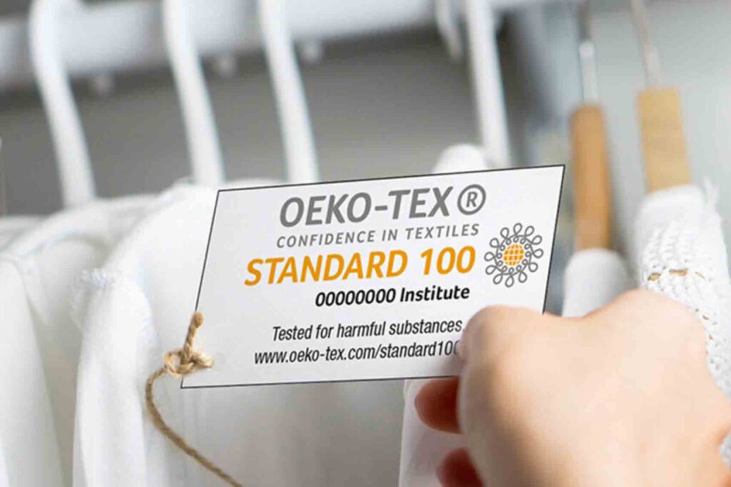 A person holds up an Oeko Tex Clothing label