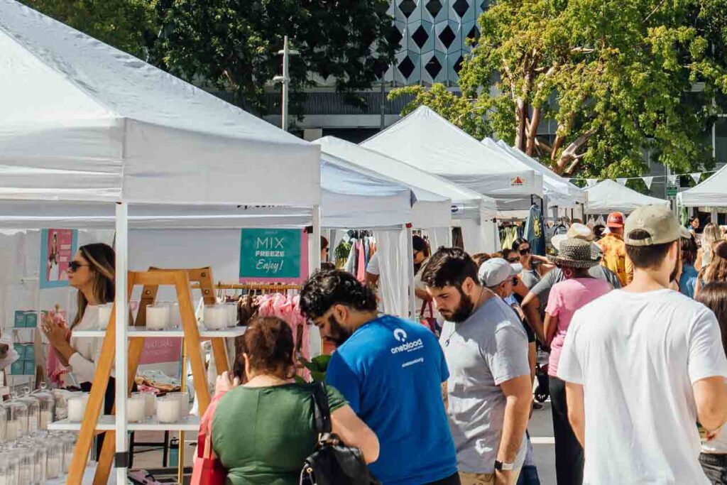 An artisan market in Miami from Markets for Makers featuring white tents and vendors.