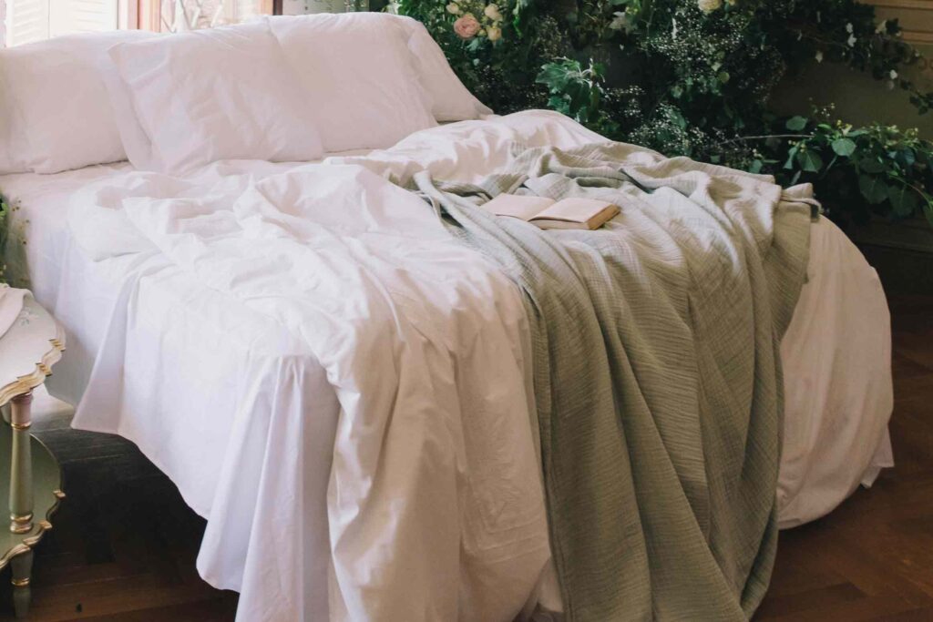 A cozy bed in a simple aesthetic room with a white bedspread