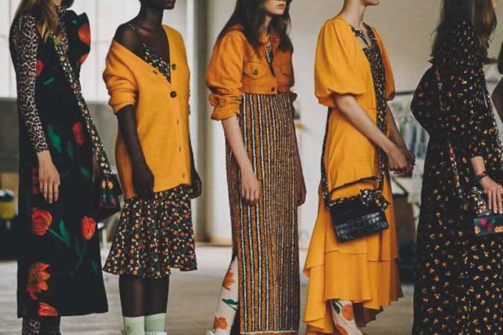 Women stand wearing yellow and animal printed clothing